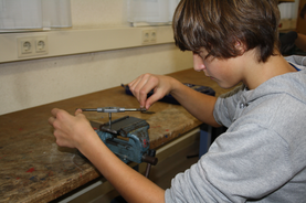 Praktische Arbeit Schüler Schüler arbeitet an einer Werkbank